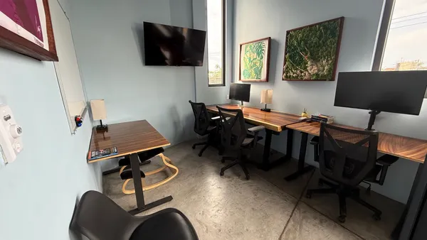 A bright and modern private office with a large window, a comfortable chair, and a spacious desk.