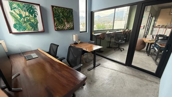 A bright and modern private office with a large window, a comfortable chair, and a spacious desk.